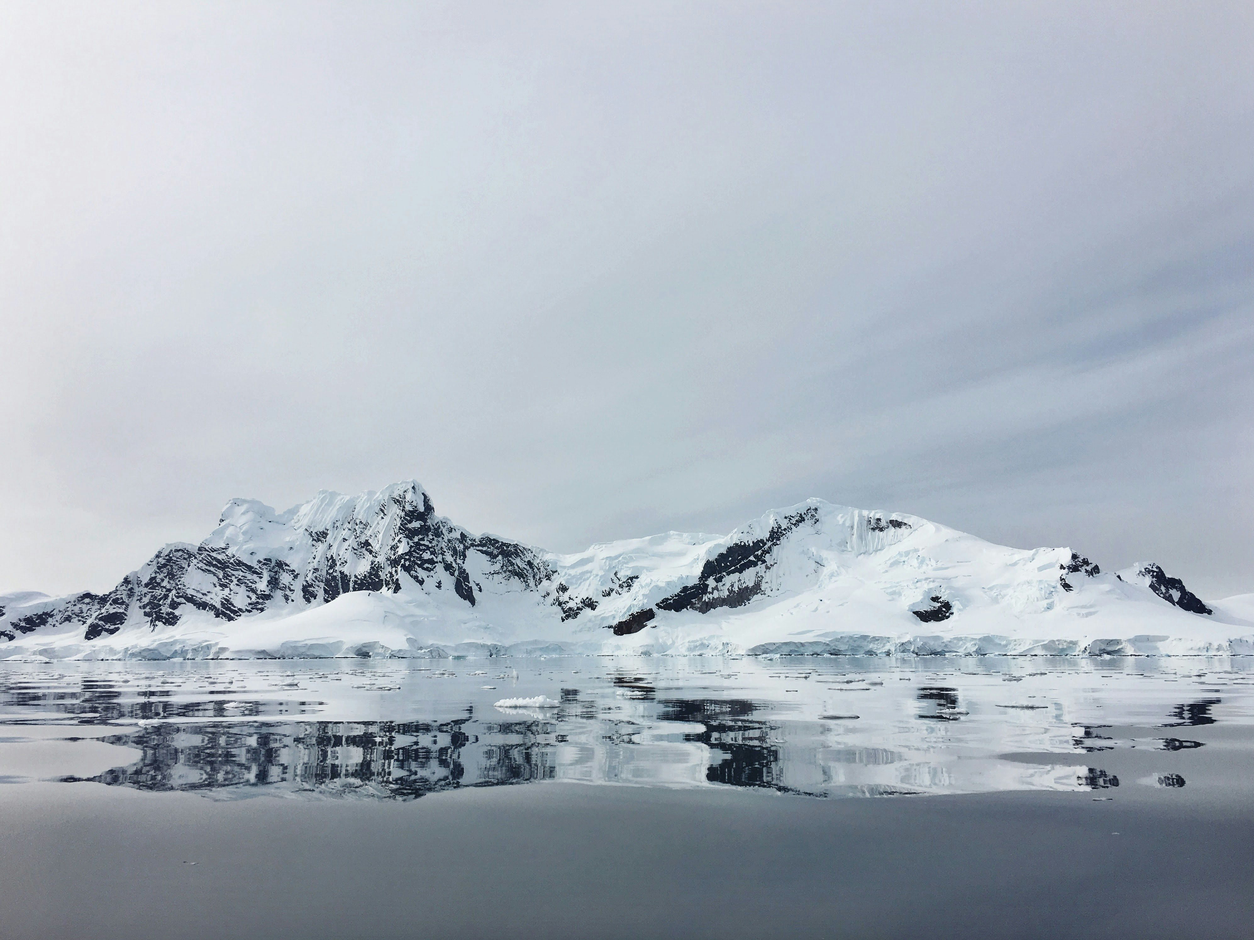 body of water near snow capped mountain